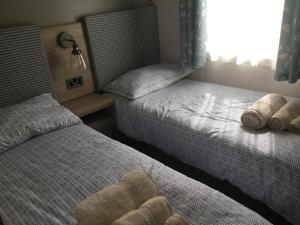 海斯廷斯Lakeside Holiday Home的一间卧室设有两张床和窗户。