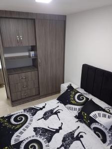亚美尼亚OroNegroApartaHoteles Espectacular Apartaestudio Amoblado Armenia, Quindio的一间卧室配有一张带黑白毯子的床