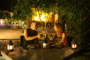 NetolpitiyaBlue Ocean Resort的坐在桌子旁的男人和女人,喝一瓶葡萄酒