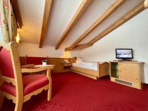 布鲁尼科海因茨酒店的配有床、电视和椅子的房间