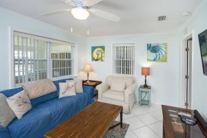 圣奥古斯丁海滩Oceans 13 Unit A的客厅配有蓝色的沙发和椅子