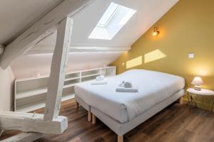 艾克斯莱班Villa des Cygnes près du lac marina Grand Port的卧室配有白色的床和天窗