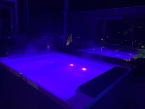 里约·迪·普斯特里亚Dolomites Alpin Penthouse, 90qm, WLAN, privat Sauna - privat Whirlpool的黑暗的房间里,泳池里灯光紫色