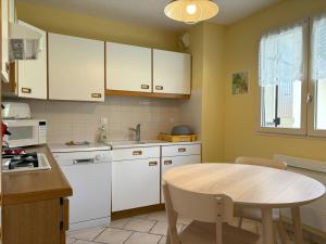 维拉尔-德朗Appartement Villard-de-Lans, 3 pièces, 6 personnes - FR-1-548-4的厨房配有白色橱柜和木桌