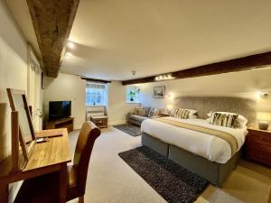 哈雷克Castle Cottage Inn的一间大卧室,配有一张床和一张沙发