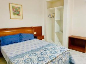 努瓦迪布Nouadhibou Guest House的一间卧室配有一张带蓝色和白色棉被的床