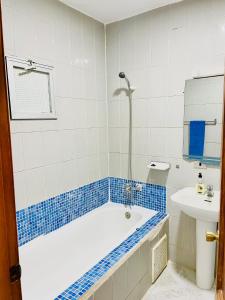 努瓦迪布Nouadhibou Guest House的蓝色和白色的浴室设有浴缸和水槽