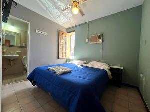 圣胡安Hotel cuesta del viento II的一间带蓝色床的卧室和一间浴室