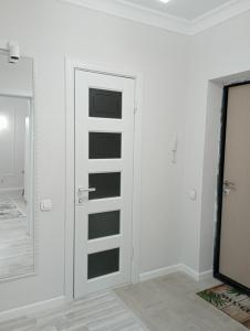 阿斯塔纳1-но комнатная квартира в центре Нур-Султана ЖК Sezim Qala 4 рядом с Барыс Ареной的一间设有门和镜子的白色客房