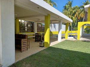 Colonia La ProvidenciaChalet san marino的庭院里设有黄色和白色的柱子和草