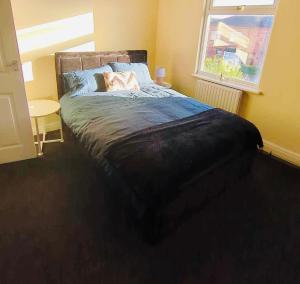 威根The Smart Stay - sleeps 5 Wigan central location的一间卧室设有一张大床和窗户