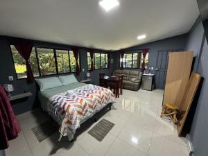 SuchitotoEl mangal B&B的一间卧室配有一张床、一张沙发和窗户。