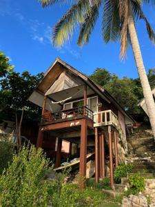 帕干岛Sea Lulaby的带阳台和棕榈树的房子
