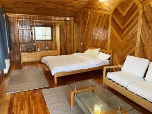 锡盖图马尔马切伊Vila Piramida的一间卧室配有两张床,卧室内配有沙发