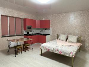 哈尔科夫Днестровский的一间卧室配有红色橱柜、一张床和一张桌子