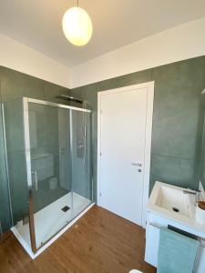 多莫多索拉Casa Dell'Edera - Holiday Apartment in Domodossola的一间带玻璃淋浴和水槽的浴室