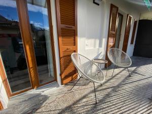 多莫多索拉Casa Dell'Edera - Holiday Apartment in Domodossola的两把椅子坐在房子的门廊上