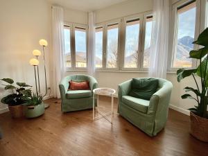 多莫多索拉Casa Dell'Edera - Holiday Apartment in Domodossola的带窗户的客房内配有两把椅子和一张桌子