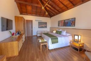 阿拉亚尔达茹达Kûara Hotel的卧室配有白色的床,铺有木地板