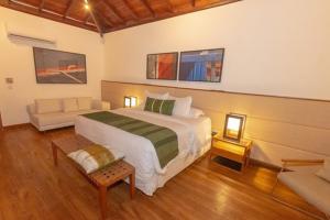 阿拉亚尔达茹达Kûara Hotel的一间卧室配有一张大床和一张沙发
