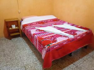 帕纳哈切尔Hospedaje Santo Domingo的一张带白色餐巾和红色毯子的床