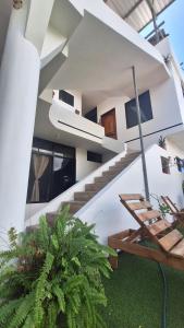 阿约拉港Galápagos Brunette Suites的白色的房子,有楼梯,绿色植物