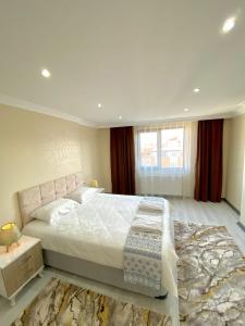 巴勒克埃西尔Clock Towers Life的卧室配有一张白色大床和地毯。