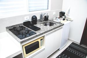 伊塔茹巴Kitnet prox a UNIFEI com Wi-Fi em Itajuba MG的白色的厨房配有炉灶和水槽