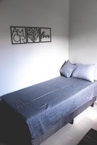 伊塔茹巴Kitnet prox a UNIFEI com Wi-Fi em Itajuba MG的白色客房的一张床位,配有蓝色毯子
