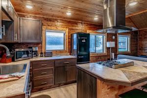 荷马Lakeshore Lodging Cabins and Suites的厨房配有木制橱柜和炉灶烤箱。