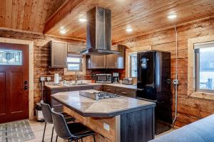 荷马Lakeshore Lodging Cabins and Suites的厨房设有木墙和黑色冰箱。