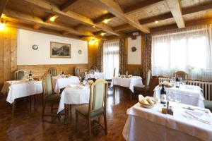 科尔蒂纳丹佩佐Hotel Bellaria - Cortina d'Ampezzo的一间设有白色桌椅的用餐室