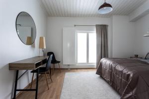 库奥皮奥Ainutlaatuinen ullakkohuoneisto ydinkeskustassa的一间卧室配有一张床、一张书桌和一面镜子
