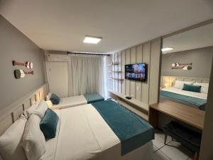 巴雷里尼亚斯Gran Lençois Resort的一间卧室配有两张床、一张桌子和一台电视。