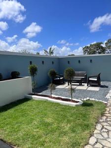 伊莎贝拉Playa y Campo Apartment #2的墙上有长椅和草地的天井