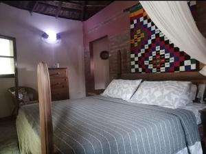 TujeringEvergreen Eco Lodge Retreat的卧室配有一张床铺,墙上挂着被子