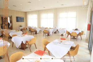 阿尤恩MH HOTEL LA CASA的一间设有白色桌椅的用餐室