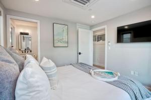 圣地亚哥Luxury Ocean Oasis 3BR I Balcony I Firepit的卧室配有白色的床和电视