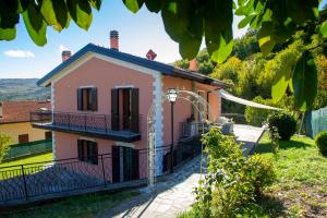 MonghidoroVilla Sumbilla, Modern, with sauna, heated jacuzzi near Tuscany的粉红色的房子,前面有一个门