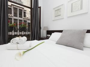巴塞罗那快乐公寓的卧室配有白色床和毛巾