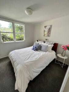 奥克兰Herne Bay 1 Bedroom Apartment - Stay Auckland的卧室配有一张带白色床单和枕头的大床。