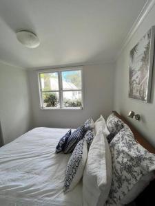奥克兰Herne Bay 1 Bedroom Apartment - Stay Auckland的卧室配有带枕头的床铺和窗户。