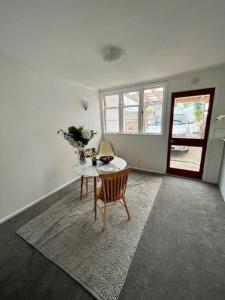 奥克兰Herne Bay 1 Bedroom Apartment - Stay Auckland的白色的客房配有桌椅和窗户。