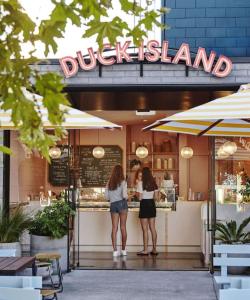 奥克兰Herne Bay 1 Bedroom Apartment - Stay Auckland的两名妇女站在小岛餐馆外面