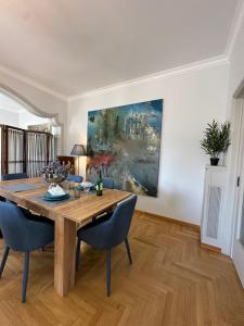 雅典2 BD Apt in Syntagma with Acropolis view的一间带木桌和蓝色椅子的用餐室