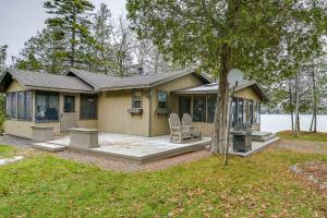 Cozy Maine Cottage on Long Lake with Screened Porch的房屋设有门廊和两把椅子