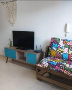 卡波布里奥kitinet Cabo Frio的带沙发和平面电视的客厅