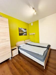 克拉科夫Cosy room Aleja Kijowska的一间卧室设有一张床和黄色的墙壁