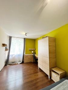 克拉科夫Cosy room Aleja Kijowska的客房设有带黄色墙壁的卧室和书桌。
