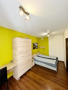 克拉科夫Cosy room Aleja Kijowska的一间卧室设有一张床和黄色的墙壁